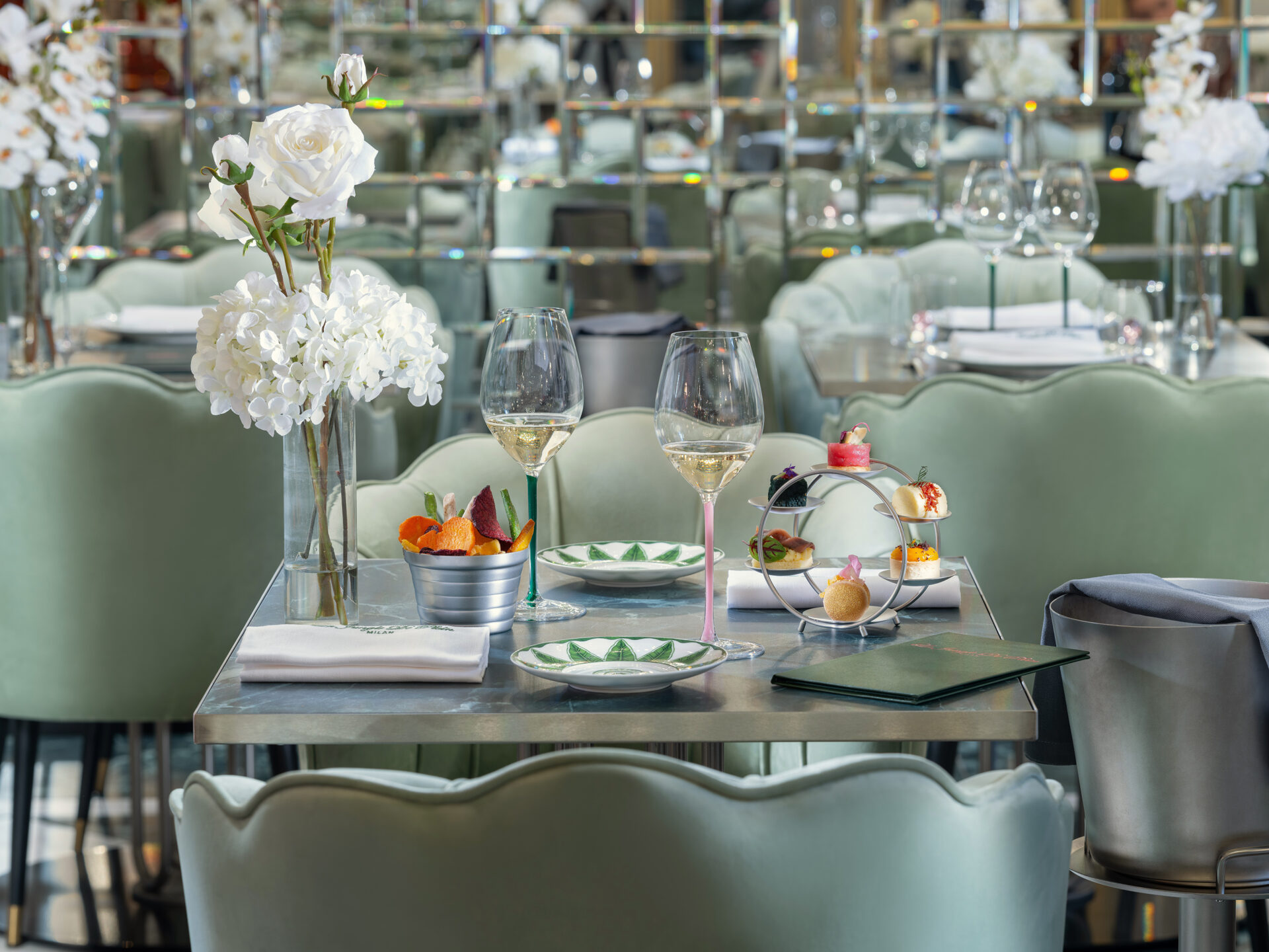 Two glasses of white wine with aperitif appetizers on an elegant table