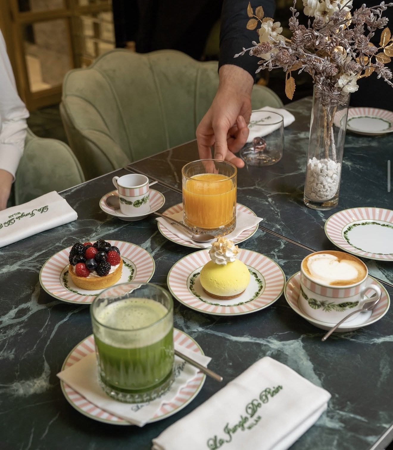 Business brunch with juices, cappuccino and pastries on marble table at La Jungle de Plein, Milan